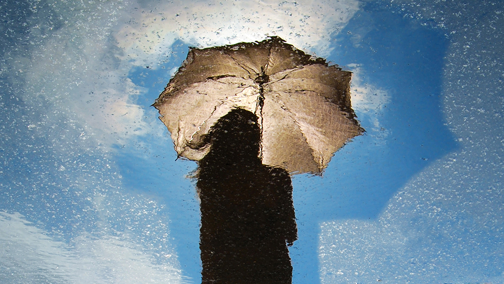 Woman with umbrella, photo by David Marcu via Unsplash