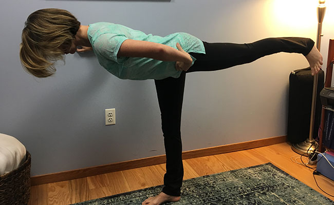 Using the wall for support while doing Warrior 3 pose during prenatal yoga