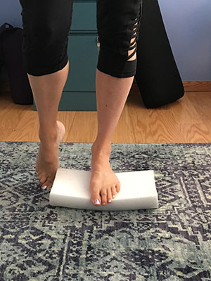Standing single leg with round part of half roller down and toes touching