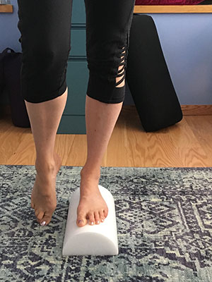 Single leg standing on a half roller with toes touching